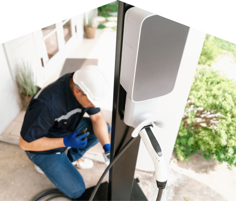 Home service electrician from M&K installing an EV charger fixed to a vertical post near a residential entryway. Home service electrician from M&K installing an EV charger fixed to a vertical post near a residential entryway.