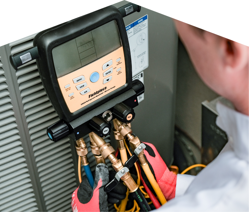A M&K home service crew member uses a digital manifold gauge to check refrigerant levels on an HVAC unit for service. A M&K home service crew member uses a digital manifold gauge to check refrigerant levels on an HVAC unit for service.