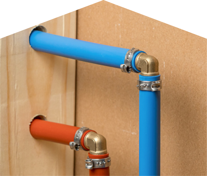 M&K kitec plumbing system with blue and orange plastic pipes connected by brass fittings and metal clamps, mounted on a wooden panel. M&K kitec plumbing system with blue and orange plastic pipes connected by brass fittings and metal clamps, mounted on a wooden panel.