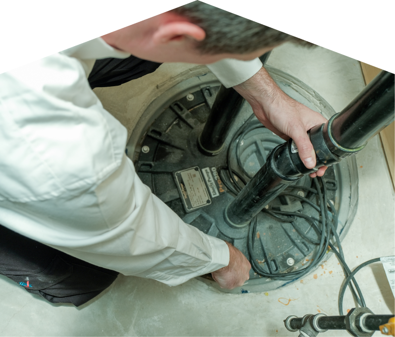 M&K sump pump specialist secures discharge piping on a sealed basin during a sump pump installation in a basement utility area. M&K sump pump specialist secures discharge piping on a sealed basin during a sump pump installation in a basement utility area.