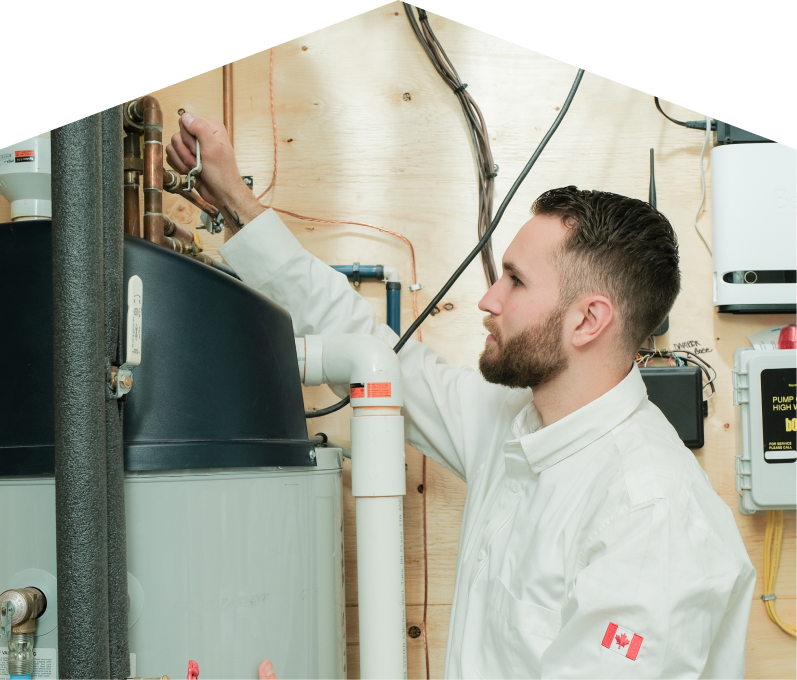 M&K water heater specialist adjusts piping on a large residential unit during a repair service, with exposed wood paneling and mounted utility components in the background. M&K water heater specialist adjusts piping on a large residential unit during a repair service, with exposed wood paneling and mounted utility components in the background.