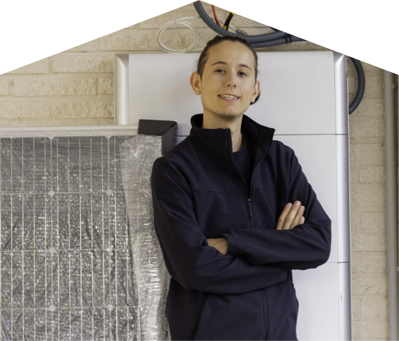 M&K specialist standing confidently with arms crossed beside newly delivered system components, including a wrapped panel and wall-mounted utility unit. M&K specialist standing confidently with arms crossed beside newly delivered system components, including a wrapped panel and wall-mounted utility unit.