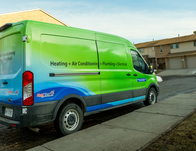 M&K service van with HVAC, plumbing, and electrical branding parked in a suburban neighborhood, promoting local trust.